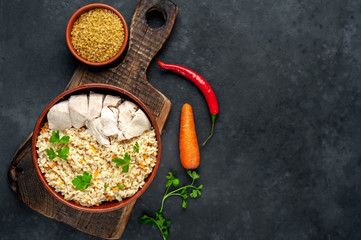 Bulgur with vegetables, chicken fillet on a stone background with copy space for your text. Healthy food