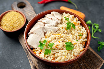 Bulgur with vegetables on a stone background. Healthy eating