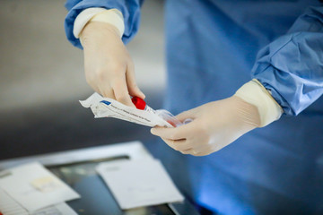 Details with the hands of a medic using a coronavirus test on a person.