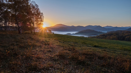 Sunrise, fog in a mountain valley. Autumn Altai.