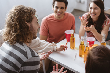 selective focus of man with sticky note on forehead playing name game with cheerful friends