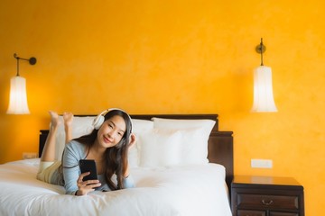 Obraz premium Portrait beautiful young asian woman using mobile cell phone with headphone for listen music