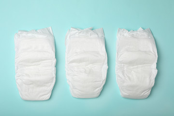 Baby diapers on turquoise background, flat lay