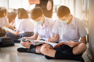 An Asian high school students in a white school uniform wearing a mask to do final exams in the midst of Coronavirus disease 2019 (COVID-19) epidemic and PM 2.5.