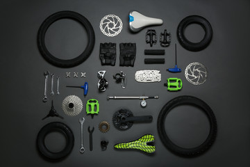 Set of different bicycle tools and parts on grey background, flat lay