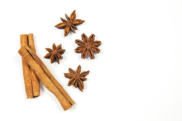 two sticks of cinnamon, one on top of the other,on the right side four stars of star anise on a...