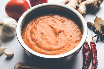 North Indian basic Curry for paneer butter masala or chicken makhanwala recipe shown with ingredients, served in a bowl. selective focus