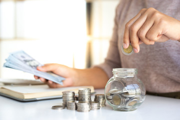 The businessman's hand holds the money in the piggy bank for saving money for future use, saving money for finance accounting concept.