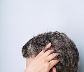 Fototapeta premium Woman of 40-50 showing naturally gray hair on light gray background. Natural ageing and diversity concept