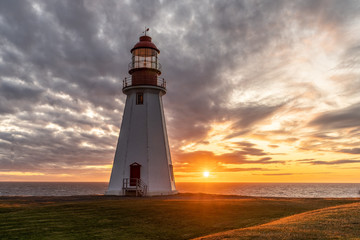 Fototapeta na wymiar Point Riche, Port a Choix, Lighthouse as the sun setting into the Atlantic Ocean on the west coast of Newfoundland