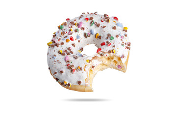  a fresh donut in white glaze is sprinkled with multi-colored dragees with a chock inside. isolate on white background