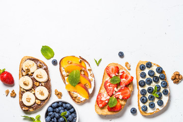 Sweet toast assortment with fresh fruit and berries on white.