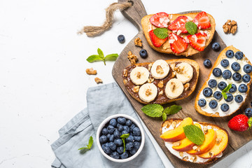 Sweet toast assortment with fresh fruit and berries on white.