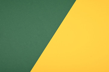 Yellow, forestgreen color paper background. Geometric flat lay. Empty space on monochrome cardboard