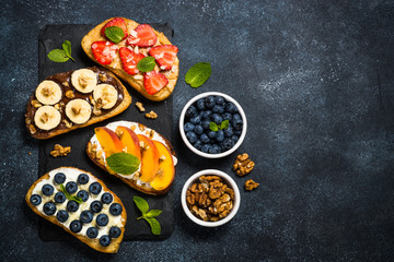 Fototapeta na wymiar Sweet toast assortment with fresh fruit and berries on black.