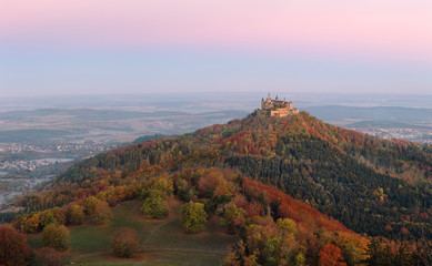 Hohenzollern Castle on mountain top at sunrise. Scenic autumn landscape. Germany.