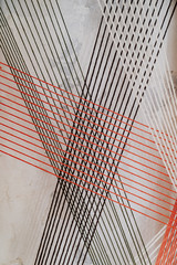 black, white and red threads on background of wall