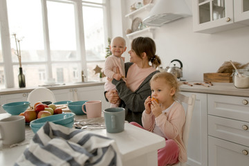 A young mother spends time with her little daughters at home.