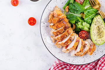 Trendy salad. Chicken grilled fillet with salad fresh tomatoes and avocado. Healthy food, ketogenic diet, diet lunch concept. Keto/Paleo diet menu. Top view, overhead, flat lay