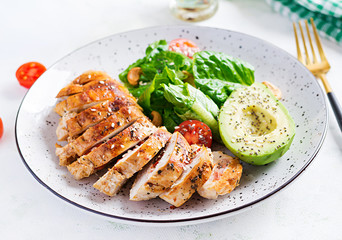 Trendy salad. Chicken grilled fillet with salad fresh tomatoes and avocado. Healthy food, ketogenic diet, diet lunch concept. Keto/Paleo diet menu.
