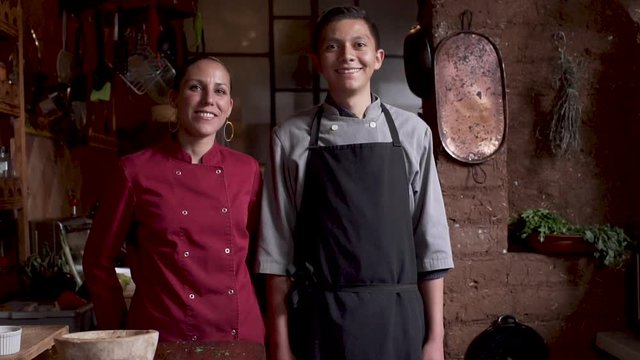 Male and female Latin restaurant workers smiling and looking at the camera