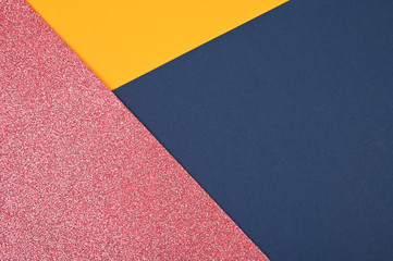 Yellow and dark blue, pink shiny color paper geometric flat lay background. Trend colors concept