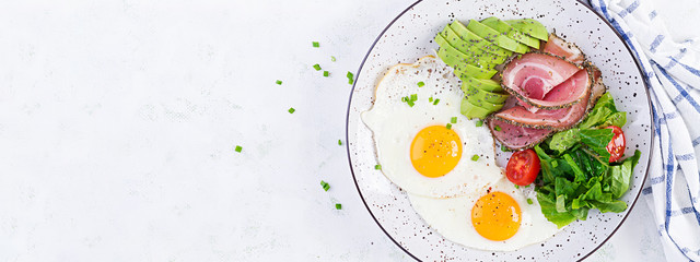 Ketogenic/paleo diet. Fried eggs, ham, avocado and fresh salad.  Keto breakfast. Brunch.  Top view, banner
