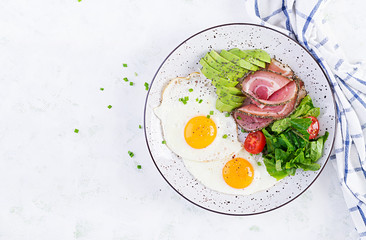 Ketogenic/paleo diet. Fried eggs, ham, avocado and fresh salad.  Keto breakfast. Brunch.  Top view, overhead