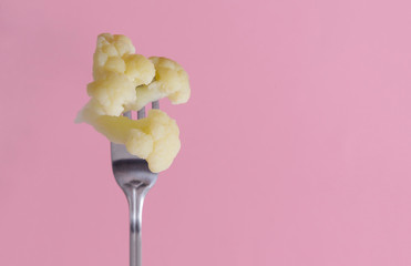 cauliflower on a fork on a pink © Elena