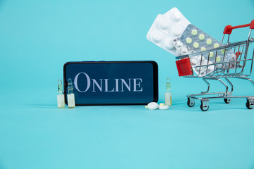 Mini shopping cart full of homeopathic remedies on laptop background. Homeopathy and internet...