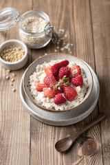 oatmeal with strawberries and raspberries in a bowl on a wooden background. Top view