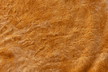 Brown real wool with a dark top texture background, orange natural wool,  fluffy fur texture for designers, close-up  wool rug