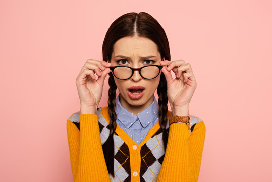 shocked female nerd in eyeglasses on pink