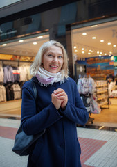 А joyful aged woman looks at shop windows