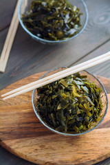 Straw seaweed. Laid out in a transparent salad bowl, on a wooden board