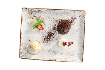 Warm chocolate fondant dessert with ice cream and strawberry on plate isolated on white background