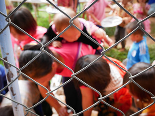 Tribal people washing dishes behind a fence in Northern Thailand