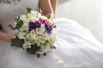 Fototapeta na wymiar Bride holding beautiful bouquet with spring freesia flowers, closeup
