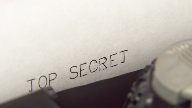 Typing TOP SECRET in black ink on an old mechanical typewriter.
