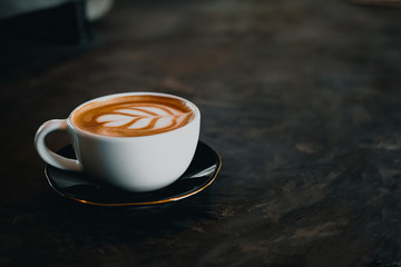 Coffee cup with latte art on old table