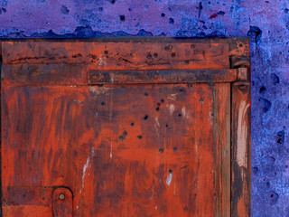 Rusty locked iron gates with bullet holes