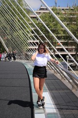 mujer en un puente con camiseta blanca y falda negra