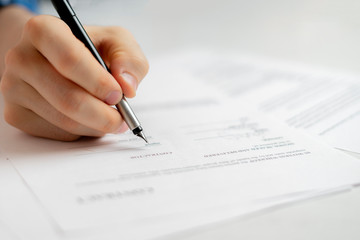 person's hand holding a pen and sign the document contract in office, agreement success concept