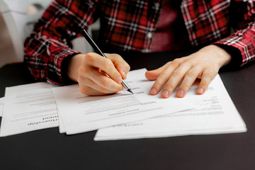 person's hand holding a pen and sign the document contract in office, agreement success concept