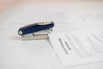 stapler and the documents files in office on the table, staple the paper sheets of resume and...