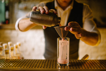 Fototapeta na wymiar barmen preparing rhubarb cocktail in highball glass