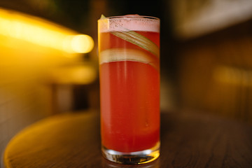 rhubarb sour cocktail in a highball glass on a wooden table