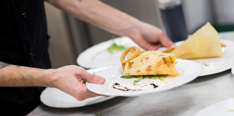 Cook at work details food at restaurant