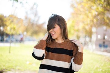 Shot of happy young woman with positive smile, has long hair, rejoices having weekend and good rest after hard working exhausting week, isolated on gray wall.