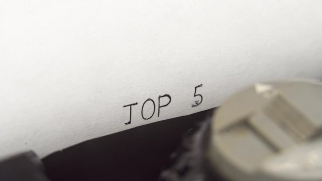 Typing TOP 5 in black ink on an old mechanical typewriter.
